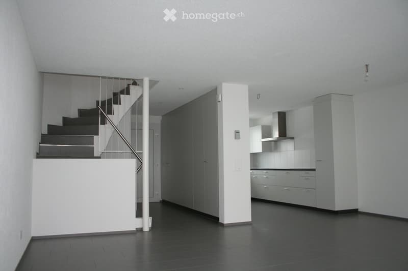 Stylish empty room, minimalistic with a modern design, stairs leading up, white tiles, open kitchen, white cabinets, tiled flooring