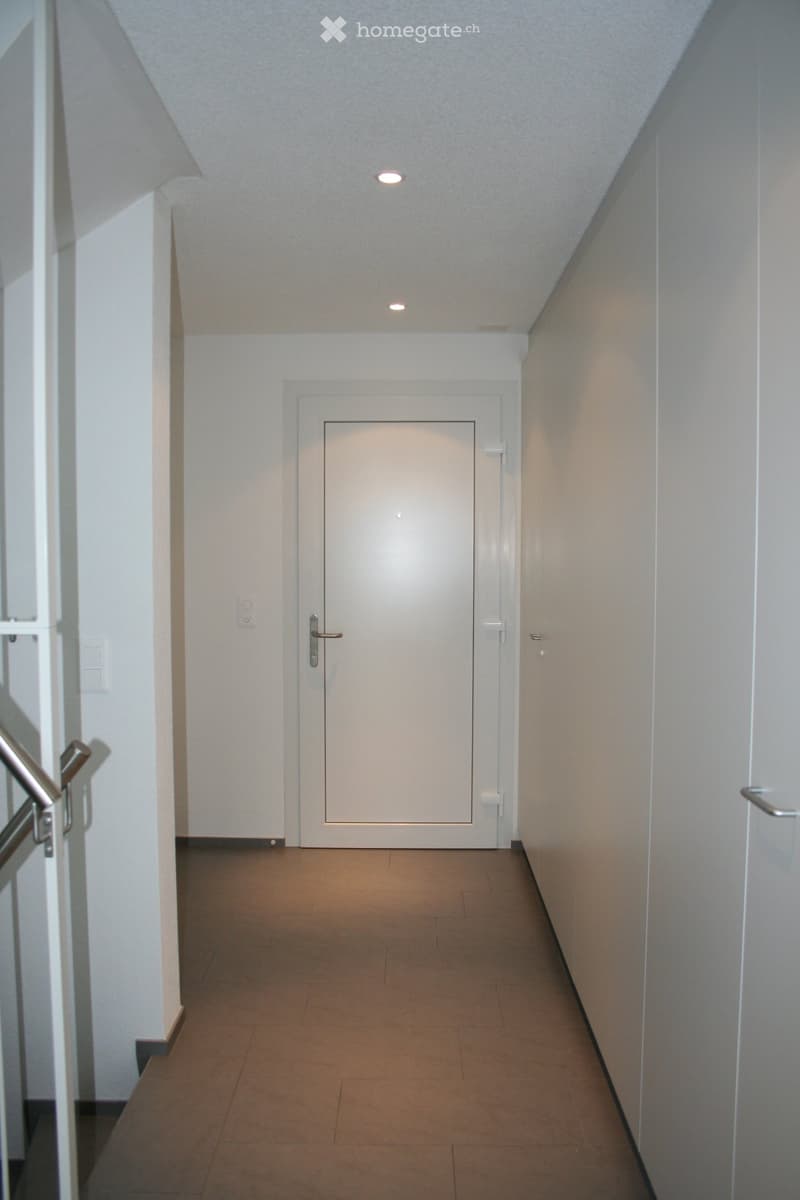 tiled corridor, white walls, white door, stainless steel railings