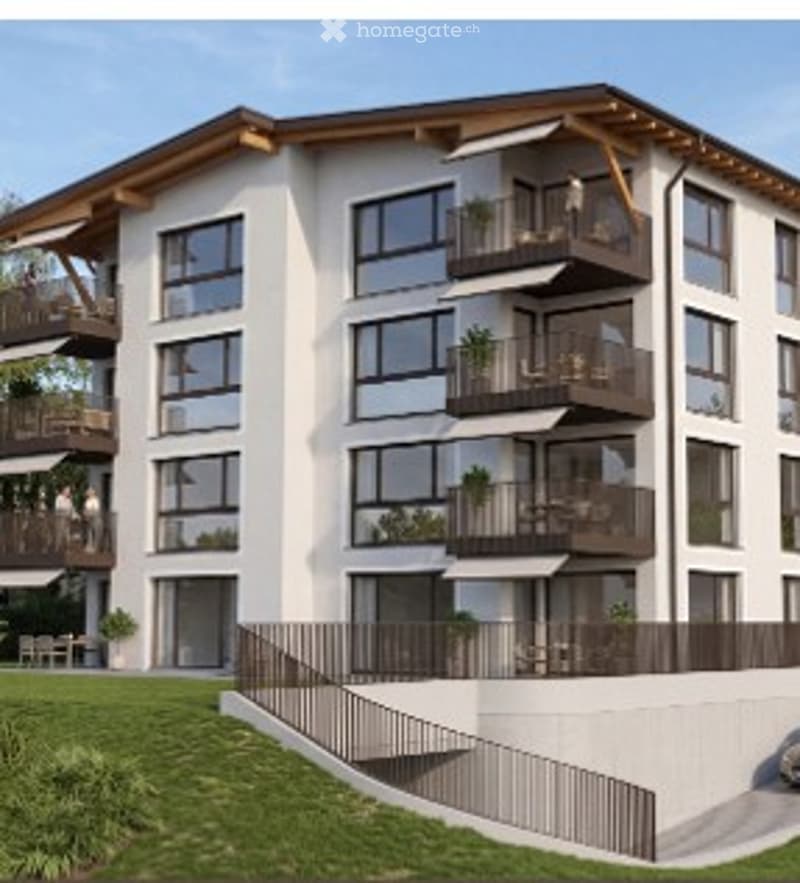 Modern multi-story residential building with balconies, large windows, and a landscaped front yard.