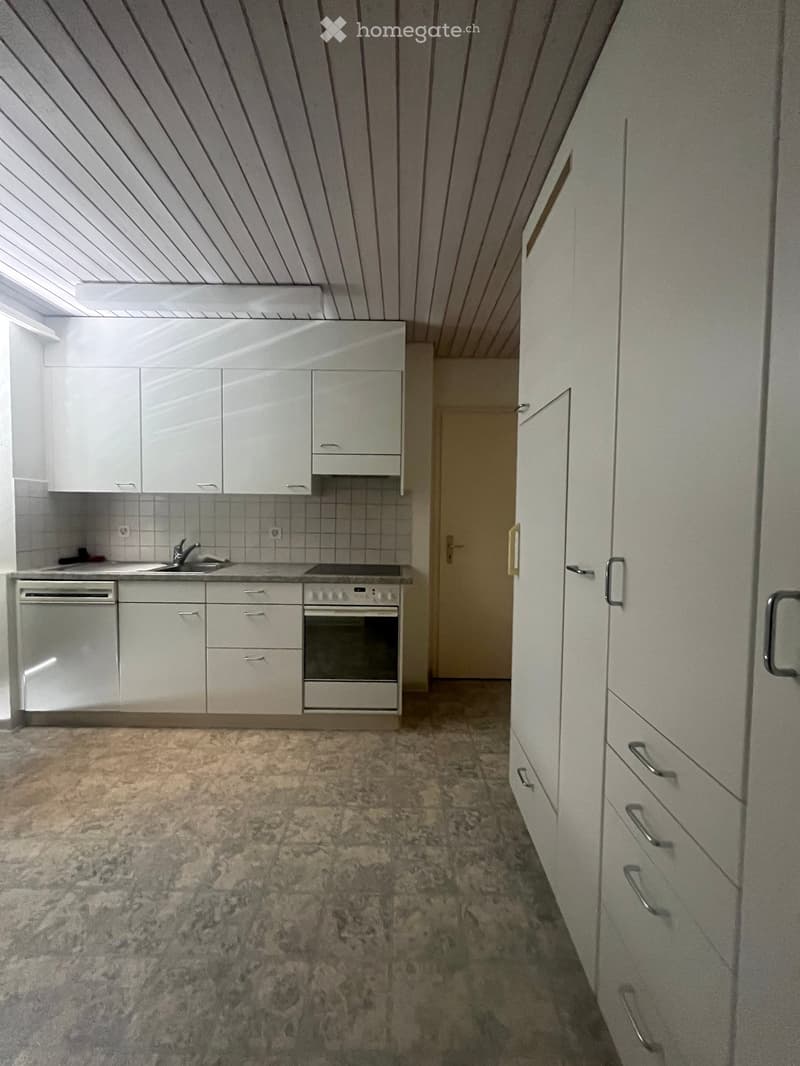 Modern kitchen with white cabinets, stainless steel appliances, and a tiled backsplash. Features a sink, oven, dishwasher, and ample cabinet storage.
