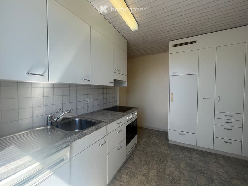 Modern kitchen with white cabinets, granite countertop, stainless steel sink, and built-in oven.