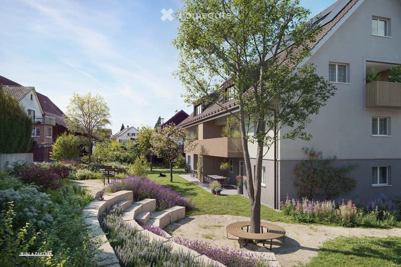 Garden with a tree, bench, flower beds, and a house with a balcony