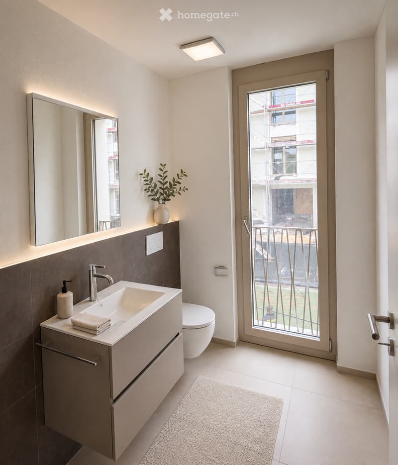 Modern bathroom with a white sink, chrome faucet, large mirror, toilet, and a small plant on the windowsill. The room features a sliding glass door leading to a balcony.
