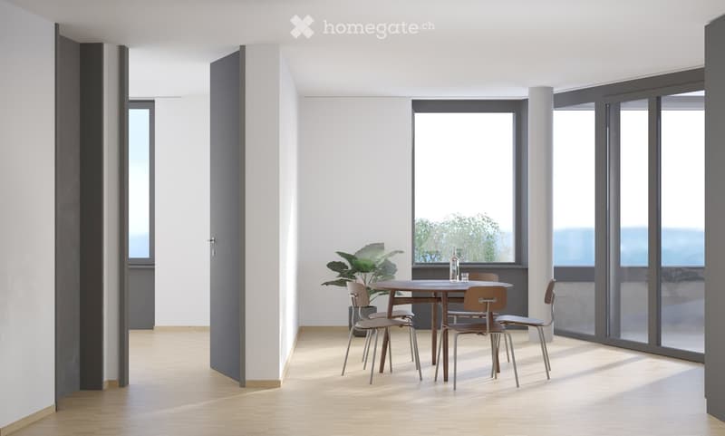 Modern dining area with a round wooden table, four chairs, a potted plant, and a bottle on the table. Large windows offer a view of greenery and the ocean.