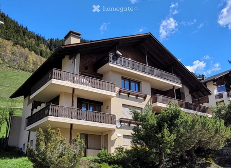 3 story house, brown wooden balconies, beige color, view of the mountain