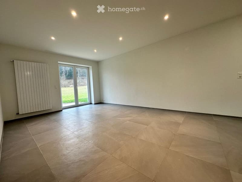 Empty room with tiled floor, white walls, and a large sliding glass door leading to an outdoor area.
