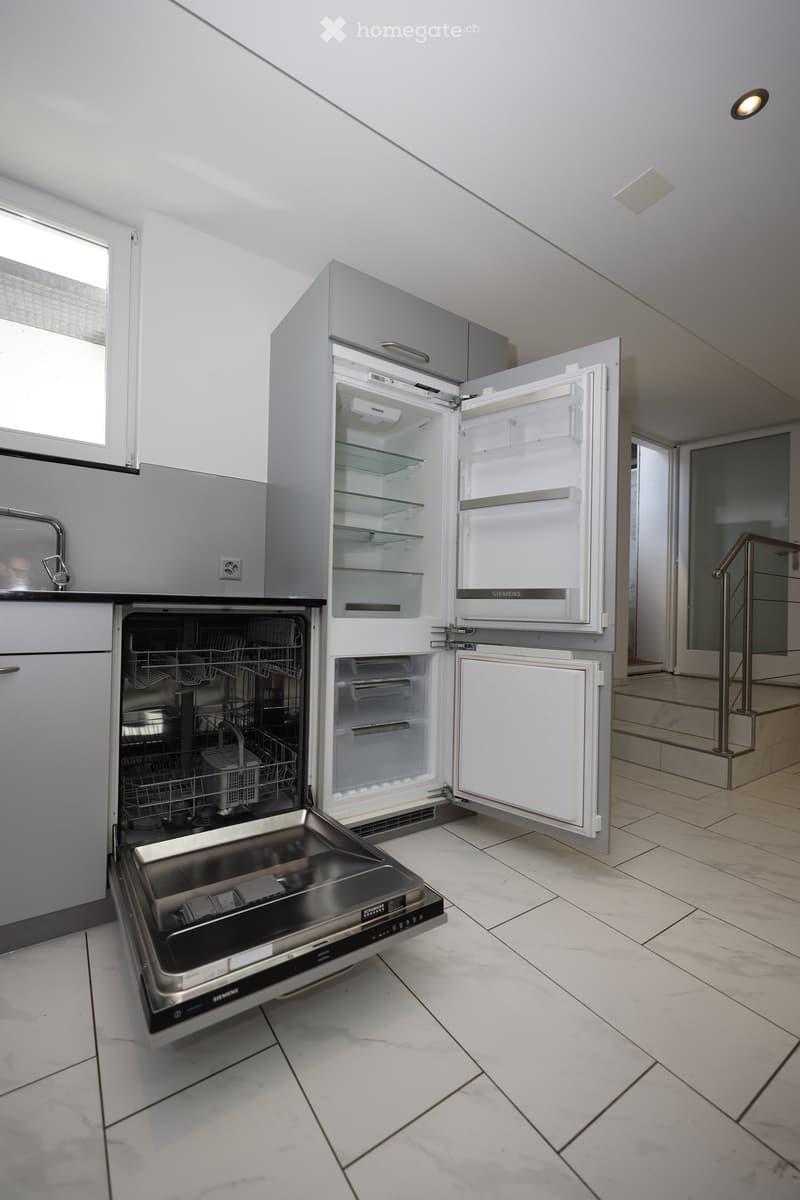 Modern kitchen with white cabinets, a stainless steel dishwasher, and a refrigerator with multiple compartments.