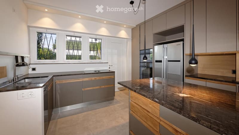 Modern kitchen with stainless steel appliances, granite countertops, and pendant lighting.