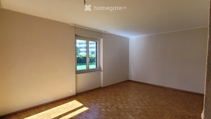 Empty room with wooden flooring, white walls, and a single window with blinds. No furniture or equipment present.