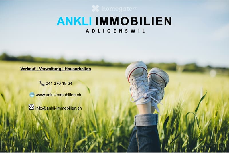 A person stands in a field of tall grass, wearing sneakers, with a clear sky and distant hills in the background. The image includes text for a real estate company.