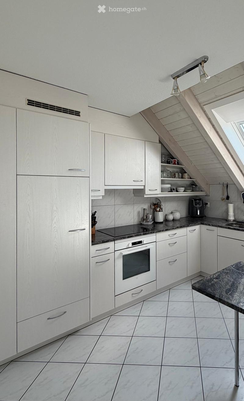 Modern kitchen with white cabinets, granite countertops, and stainless steel appliances including an oven, microwave, and sink.