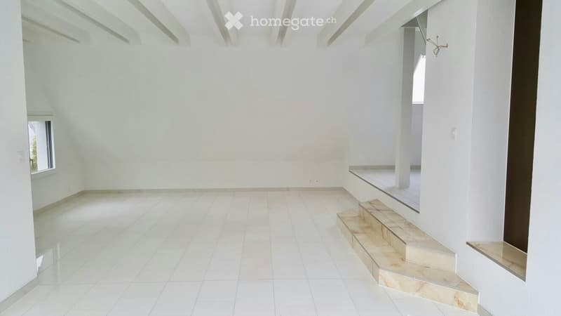 Empty room with white walls, tiled floor, and a small staircase leading to another level.