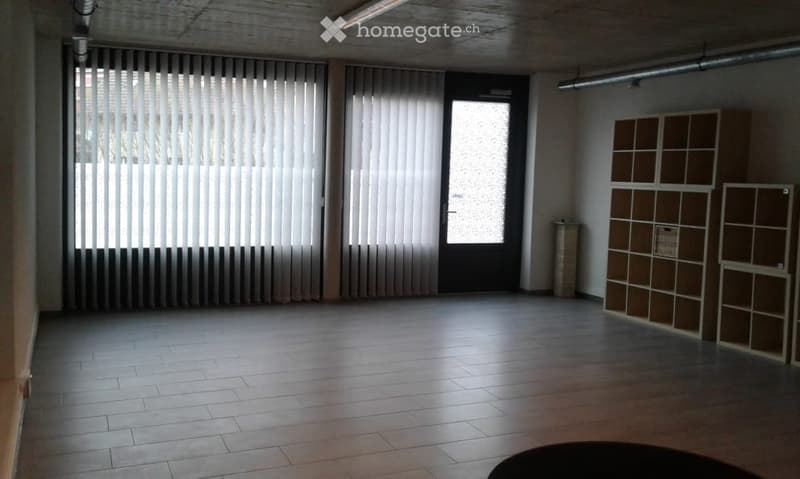 Empty room with large windows, doors, wooden shelves, wooden flooring