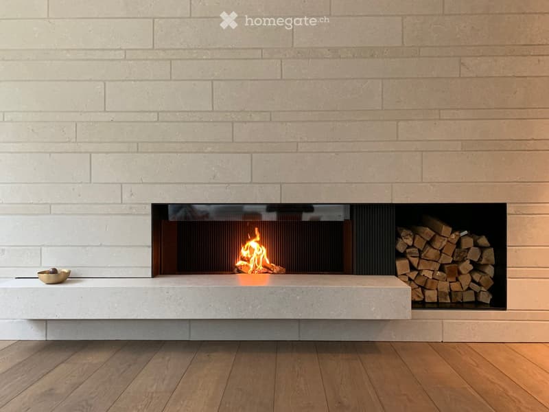 white brick wall, fireplace with fire, pile of wood, bowl