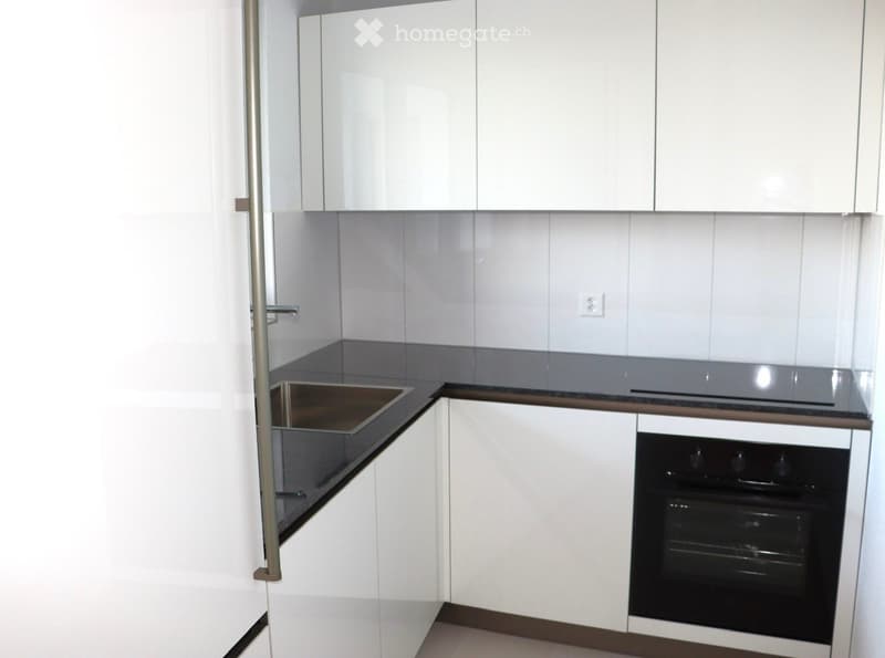 Kitchen. Modern kitchen with white cabinets, stainless steel sink, and built-in oven.