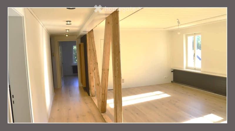 Empty hallway with wooden flooring, white walls, and recessed lighting. No furniture or equipment present.