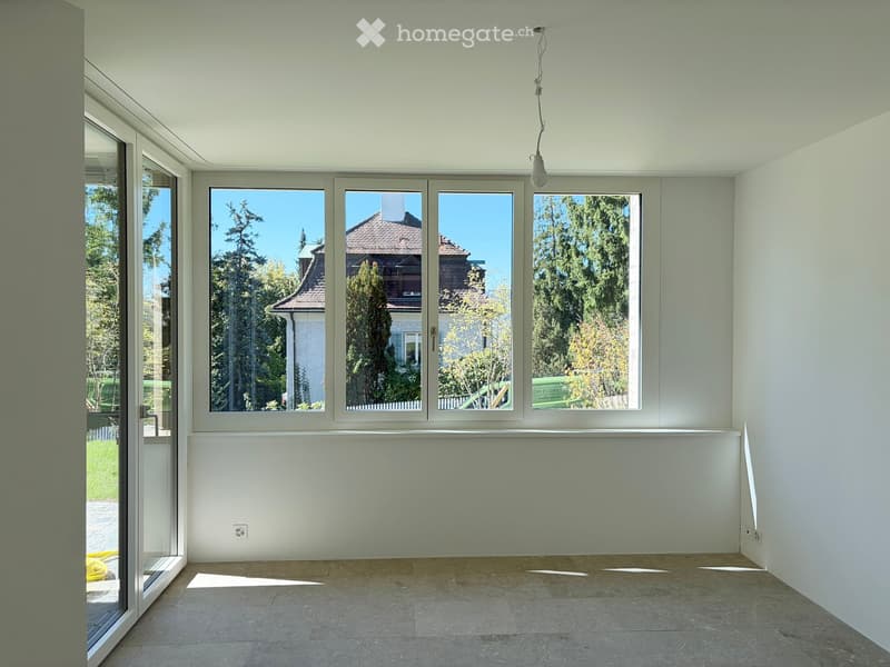 Empty room with large windows, tiled floor, and white walls. No furniture or equipment present.