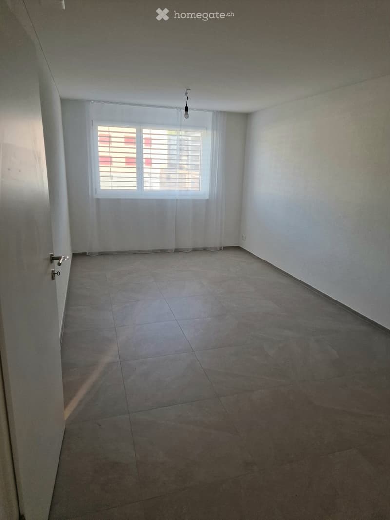 Empty room with tiled floor, white walls, and a window with blinds. No furniture or equipment present.
