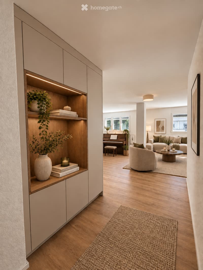 Modern living room with light wood flooring, a cream-colored sofa, armchair, coffee table, piano, and decorative items including vases, books, and candles.