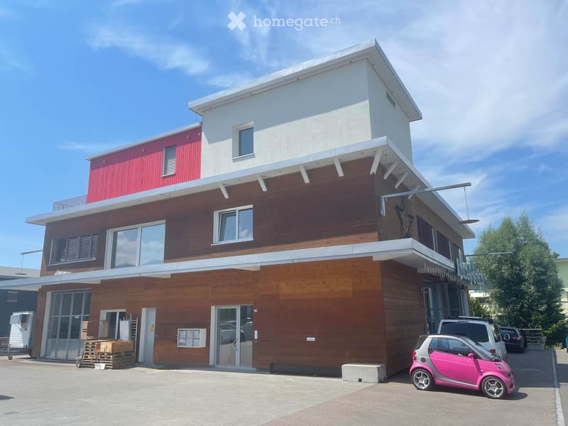 2 story house, red and brown wood facade, glass windows, parking lot, pink car parked