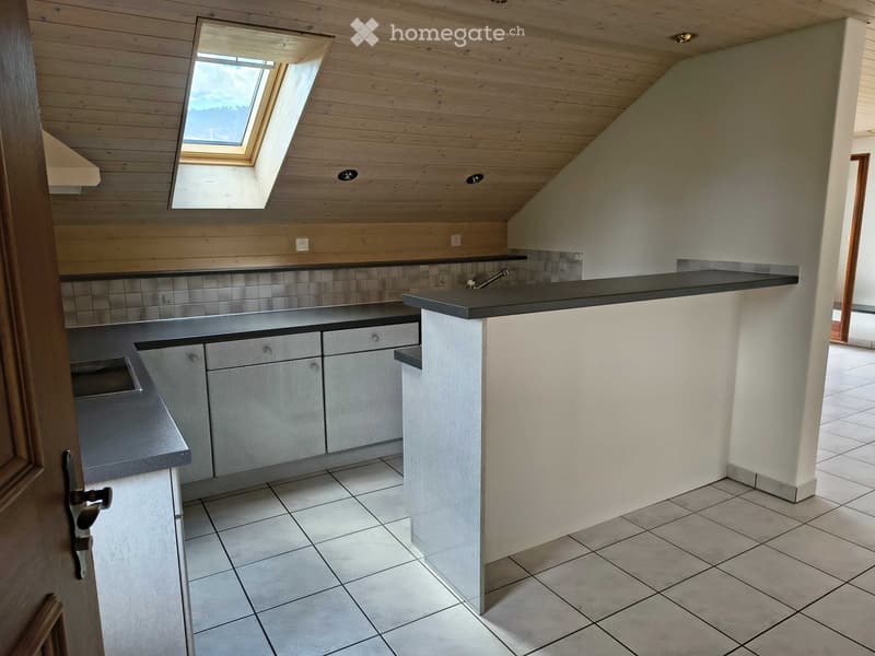 Modern kitchen with light wooden ceiling, tiled backsplash, and white tiled floor. Features built-in cabinets, a sink, and a skylight window.