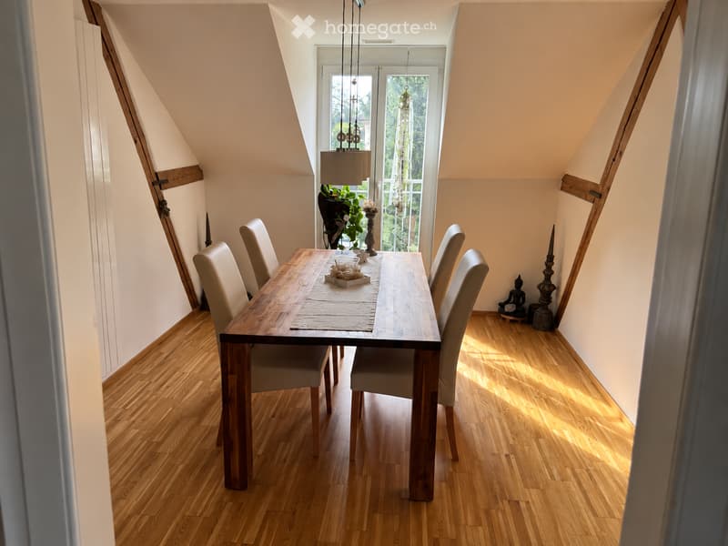 Bright, airy dining area with wooden floor, large window, and modern furniture including a dining table and chairs.