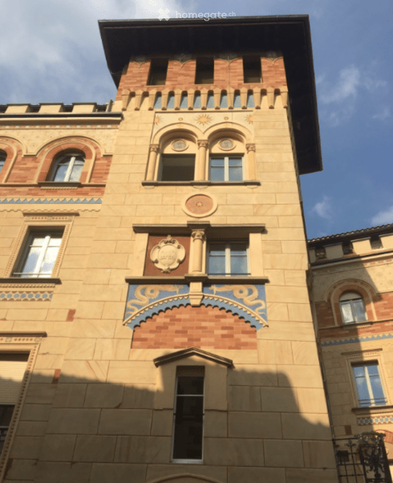 A multi-story building with ornate architectural details, including decorative moldings, arched windows, and intricate patterns on the facade.