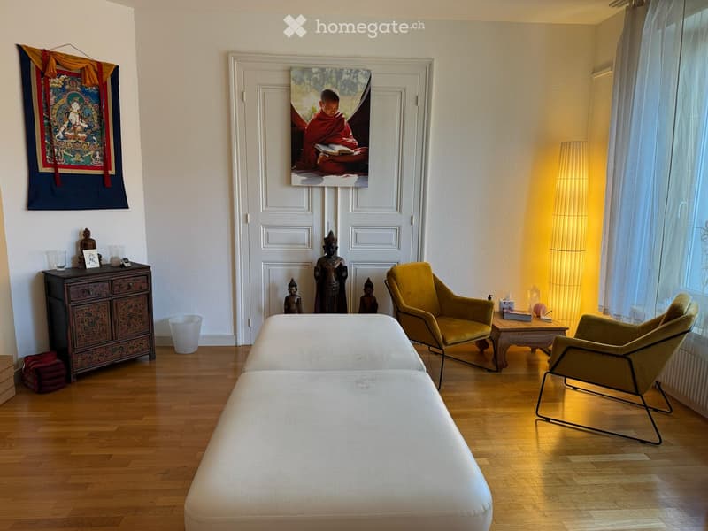 two white couches, two yellow chairs, white wooden floor, wooden table, picture on the wall, wooden cabinet with statue, white curtains, yellow lamp, stack of towels