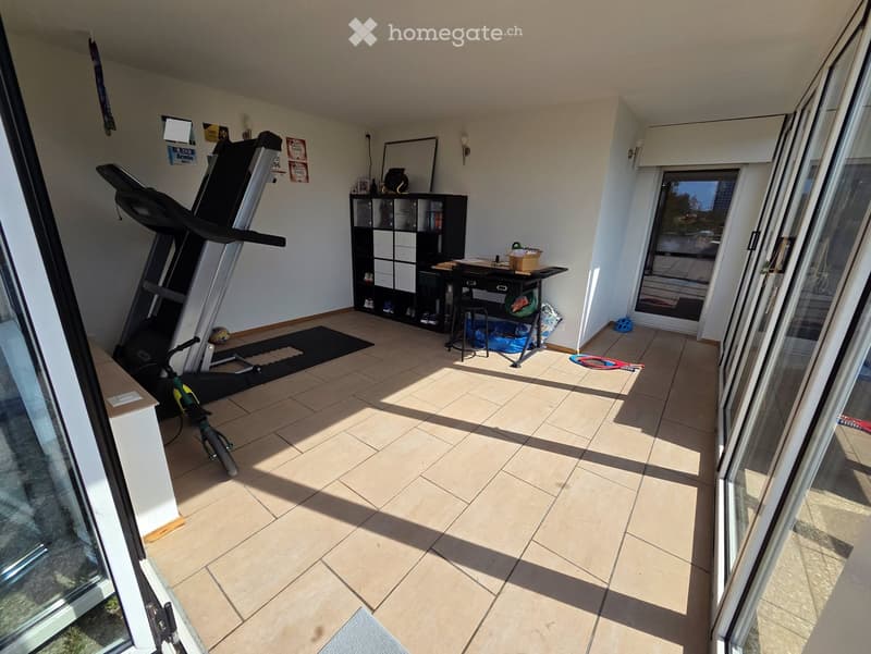 Balcony with tiled floor, treadmill, bicycle, small table, stool, shelf, mirror, and storage box.