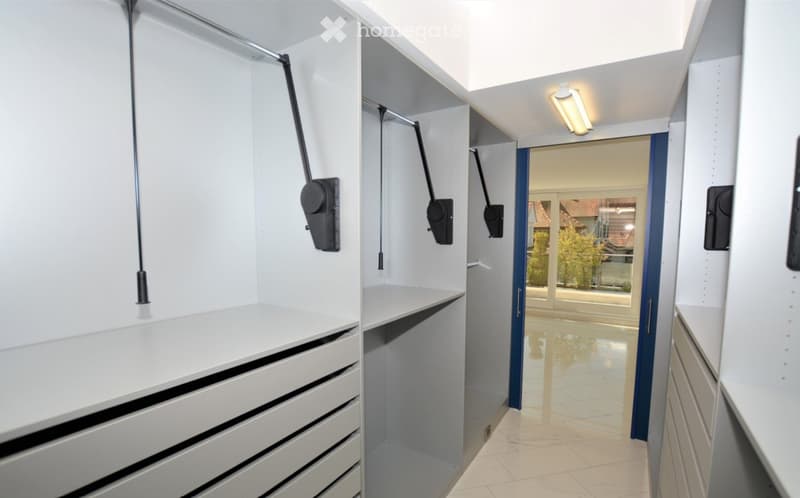 Modern, well-lit hallway with built-in storage units and a sliding door leading to an outdoor area.
