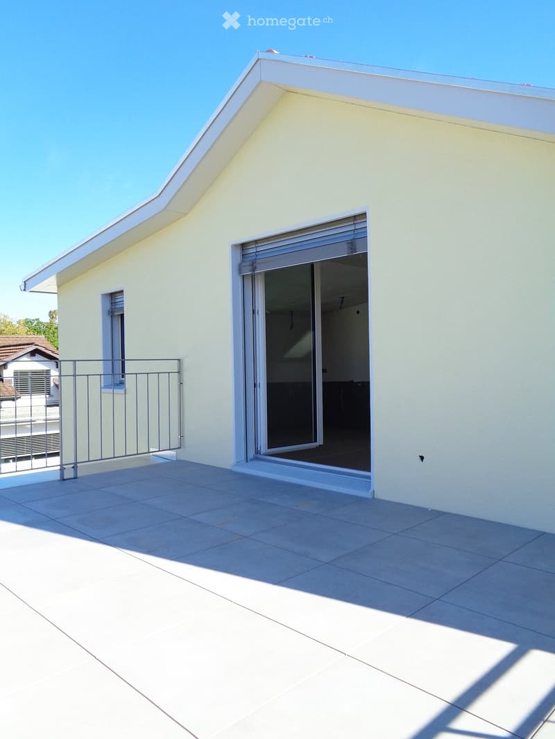 Balcony with tiled floor, metal railing, and sliding glass door leading to interior space.
