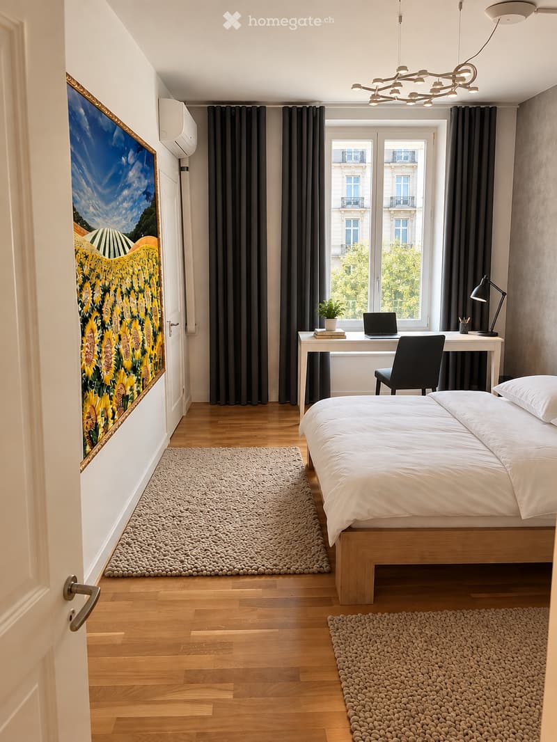 Modern bedroom with a wooden bed, white bedding, a desk with a laptop, a chair, a table lamp, a potted plant, and a large picture frame on the wall. The room features wooden flooring, a large window with dark curtains, and a textured rug.