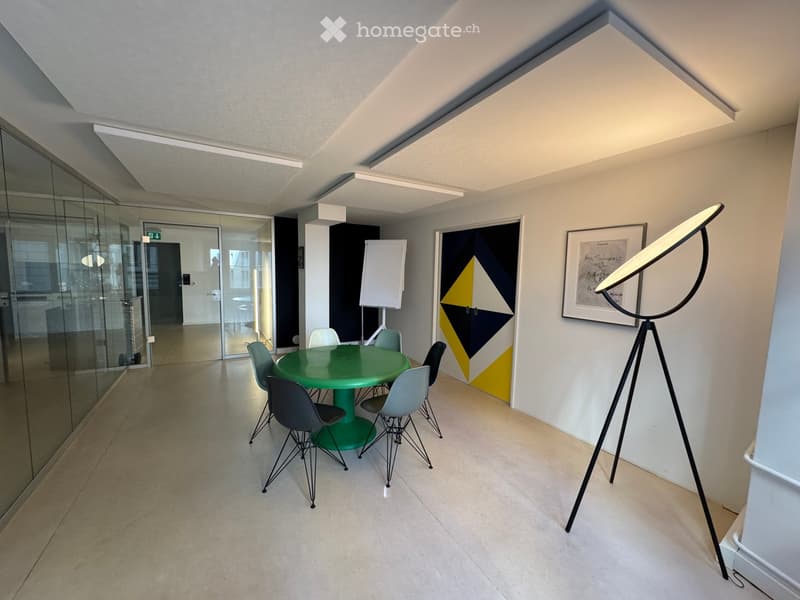 modern office meeting room with glass walls, green table, white chairs, white board, artwork, floor lamp