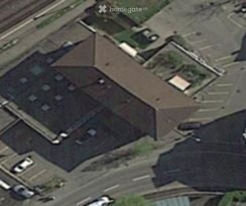two story building with multiple parking places, brown roof