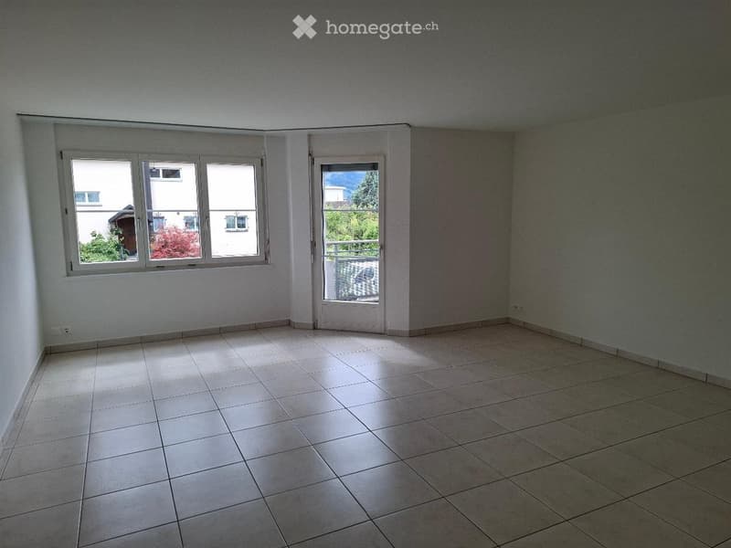 Empty room with tiled floor, large windows, and a door leading to a balcony.