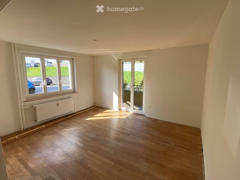 empty room, wooden floor, white walls, sliding glass doors to balcony, windows, radiator