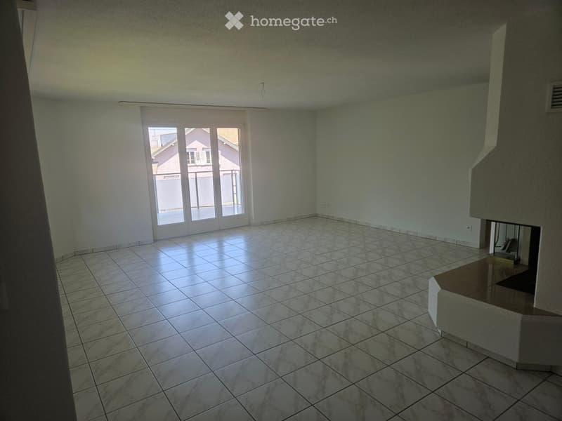 Empty room with tiled floor, white walls, and large sliding glass doors leading to a balcony.