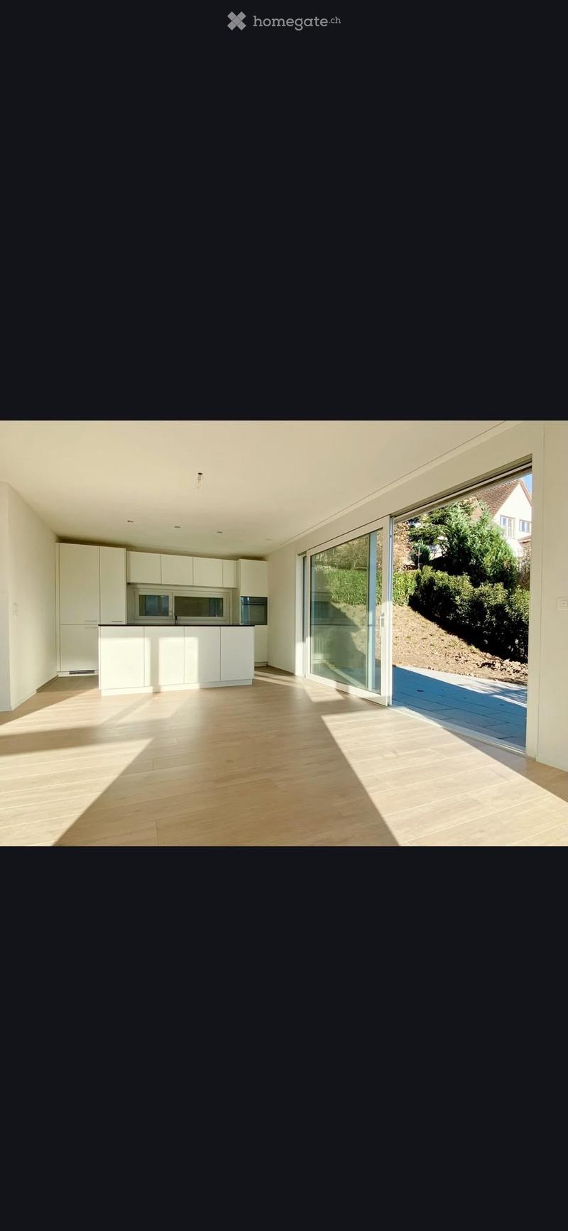 Bright, modern kitchen with white cabinets, a central island, and large sliding glass doors leading to an outdoor area.