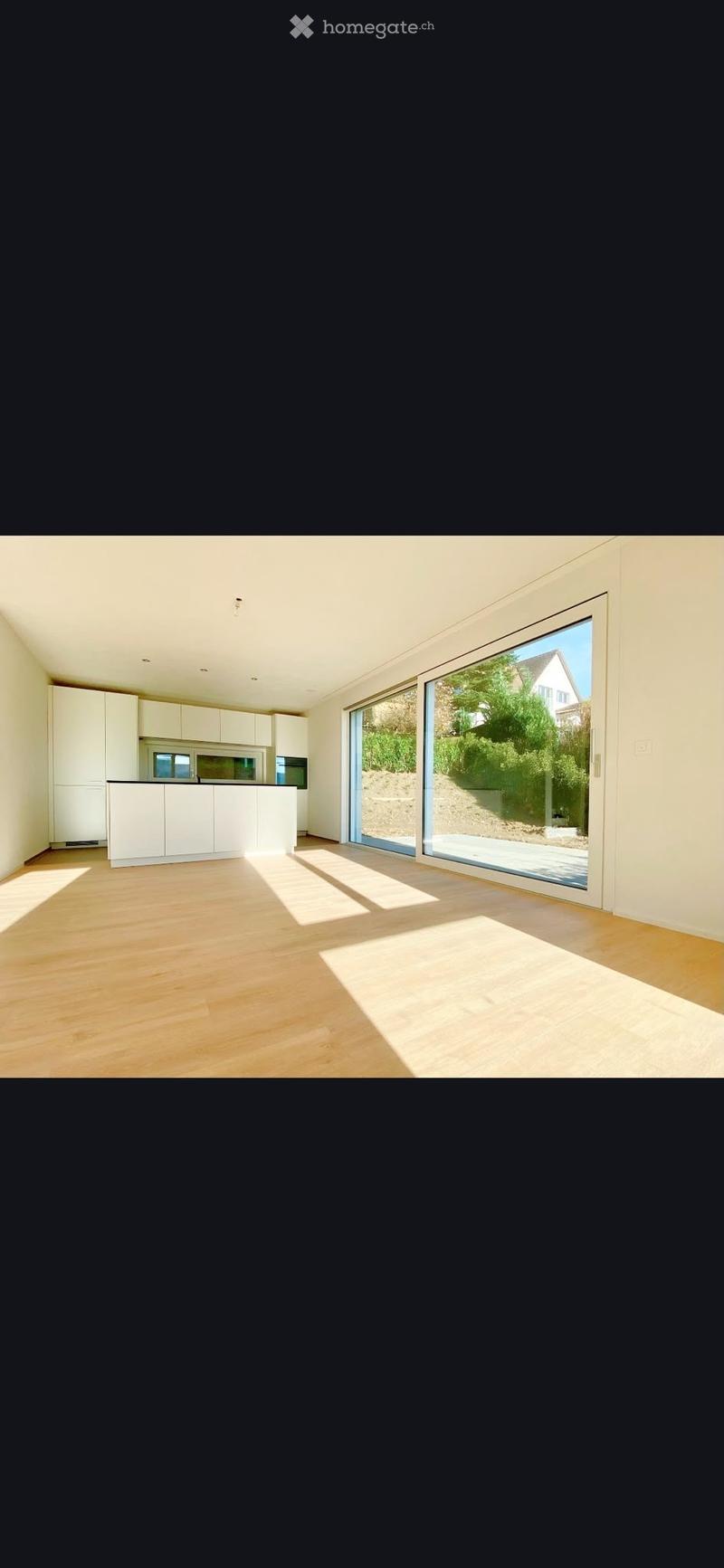 Open-plan kitchen with white cabinets, a countertop, and large sliding glass doors leading to an outdoor area.