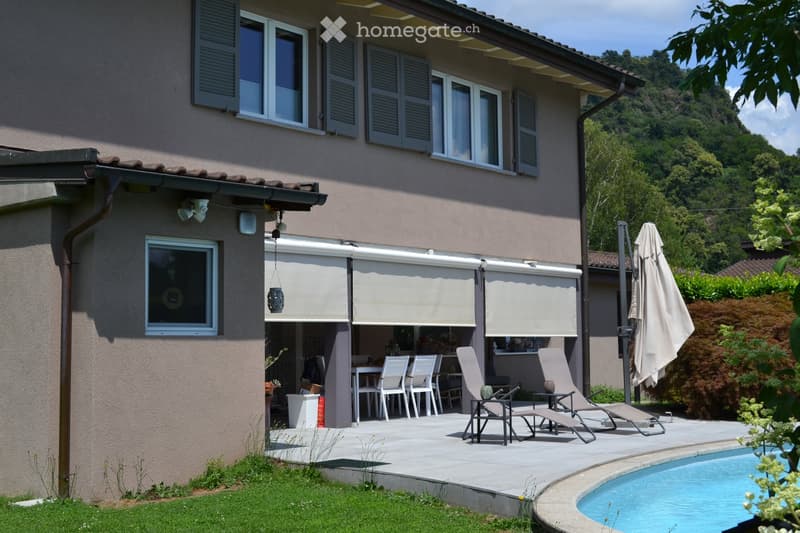 Outdoor area with a swimming pool, patio furniture, and a covered seating area attached to the house.