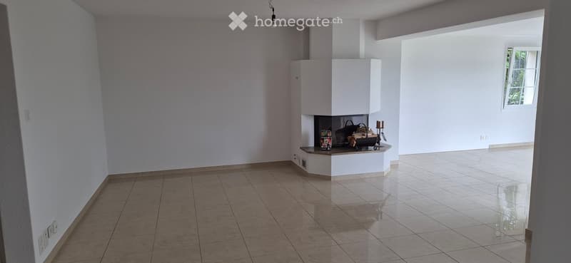 Empty room with tiled floor, white walls, and a built-in fireplace with a small shelf holding decorative items.