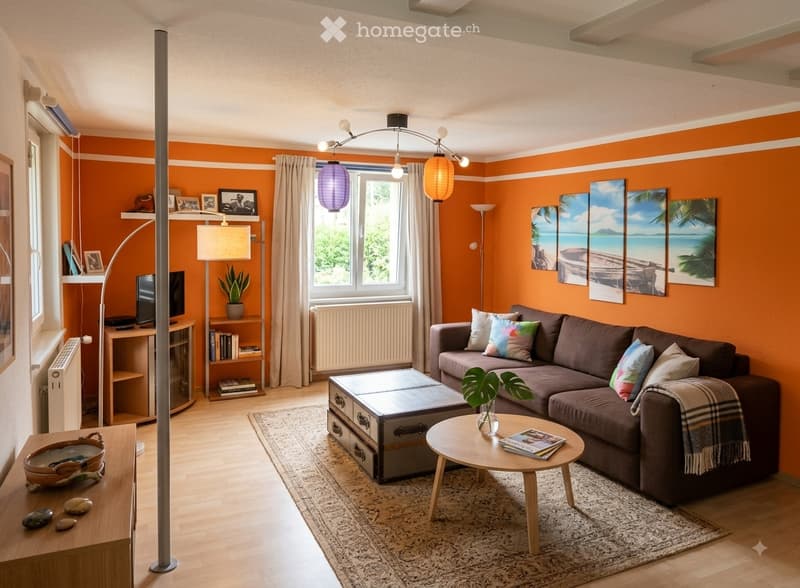 Bright living room with orange walls, a grey sectional sofa, a coffee table, a small round table with magazines, a floor lamp, and several picture frames on the wall.