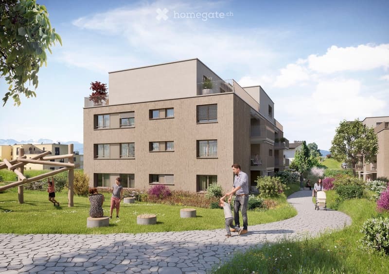 Modern multi-story residential building with balconies, surrounded by a landscaped garden area with pathways, seating, and play equipment.