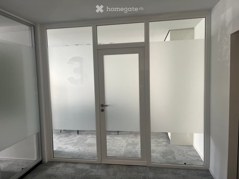 Empty room with large glass doors and windows, carpeted floor, and white walls.