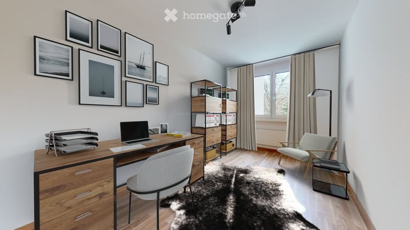 Modern, well-lit study or home office with a wooden desk, laptop, ergonomic chair, shelving unit, floor lamp, and decorative picture frames on the wall.