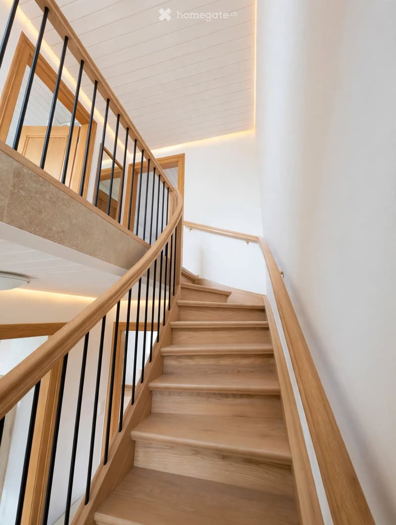 Spiral staircase with wooden steps and handrails, modern design, white walls, and recessed lighting.