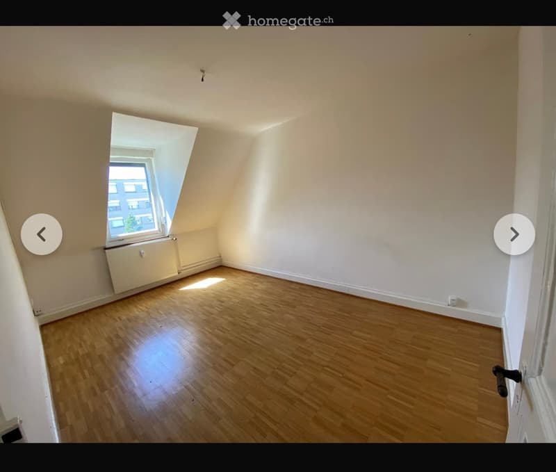 Empty room with wooden flooring, white walls, and a large window letting in natural light. No furniture or equipment is present.