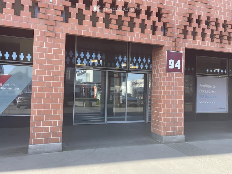 Entrance to a building with a glass door, brick facade, and signage displaying the number 94.