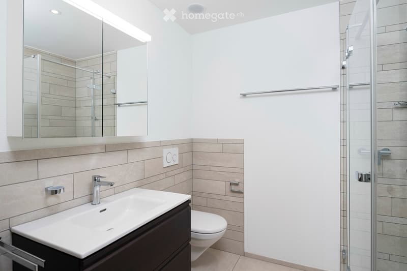 Bathroom with white wall, tile flooring, glass shower, sink, mirror, and toilet