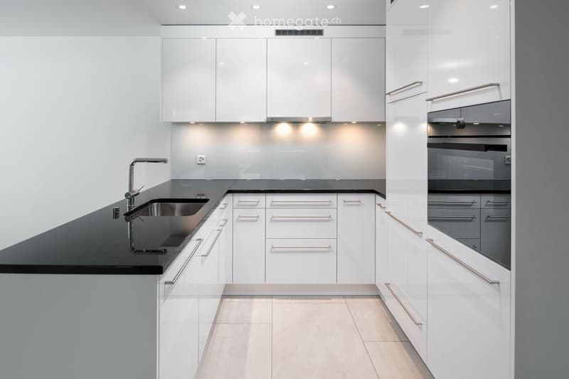 modern kitchen, white cabinets, black granite countertop, stainless steel sink, built-in dishwasher, built-in oven